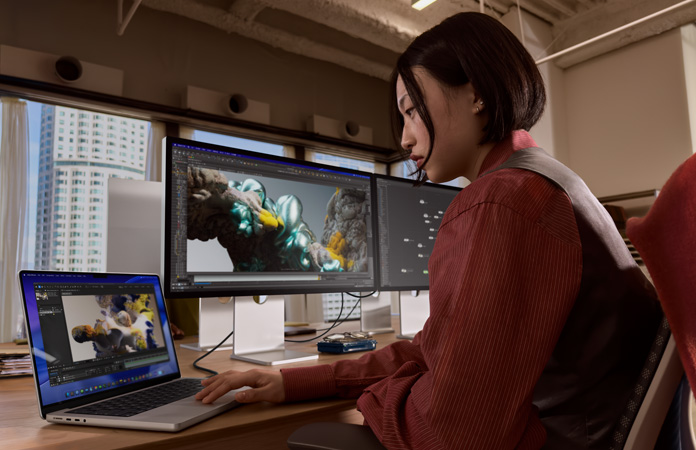 Egy Studio Display XDR-hez csatlakoztatott MacBook Prón dolgozó ember irodai k?rnyezetben