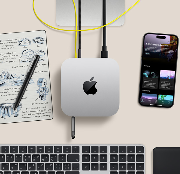 擺放在桌面的銀色 Mac mini 俯視圖，展示數(shù)條連接線和隨身碟插入連接埠，旁邊放著無線鍵盤、觸控式軌跡板、iPhone 和筆記本