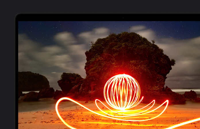 écran de MacBook Pro affichant une installation artistique extrêmement lumineuse sur une plage, mettant en valeur le contraste de l’écran grace à la gamme dynamique extrême